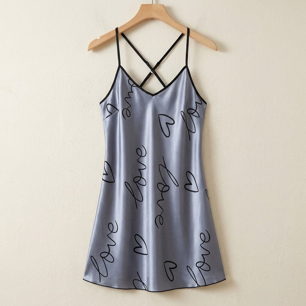 The Luna Satin Slip Dress in Love Script, on a wooden hanger