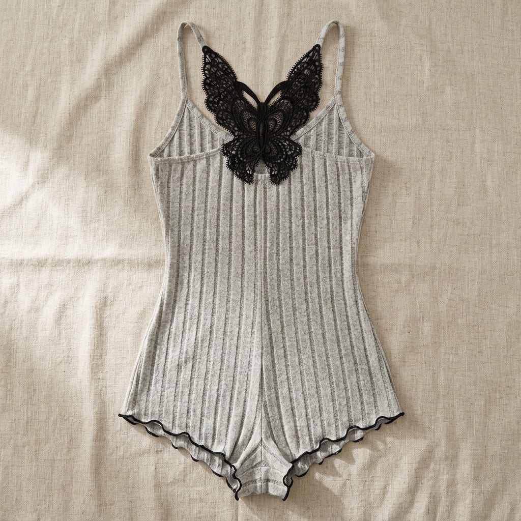 The Viola Ribbed Sleep Romper in Burgundy in Grey, laid flat on linen